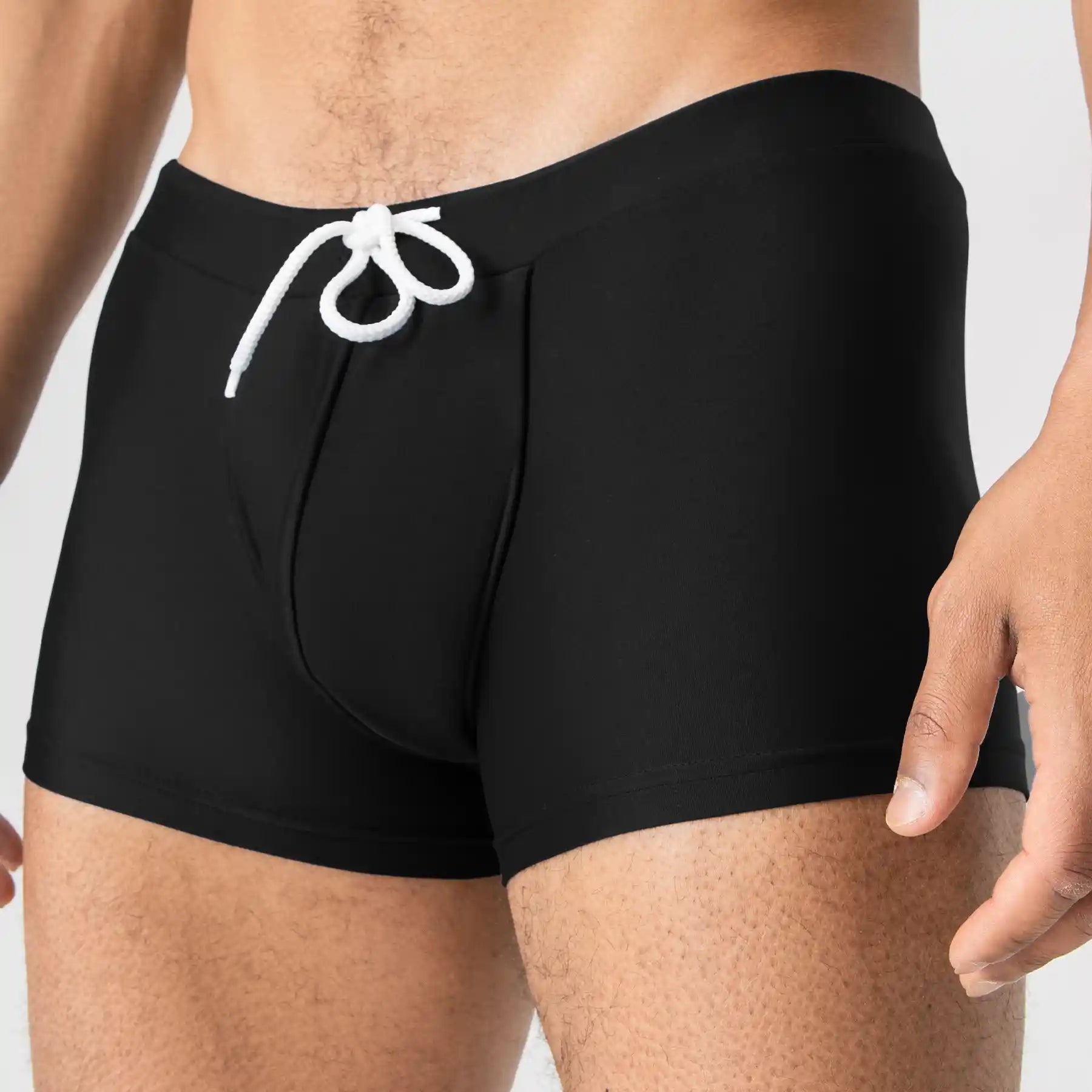 Black men’s swim trunks with white drawstring by Man’s SET, close-up front view