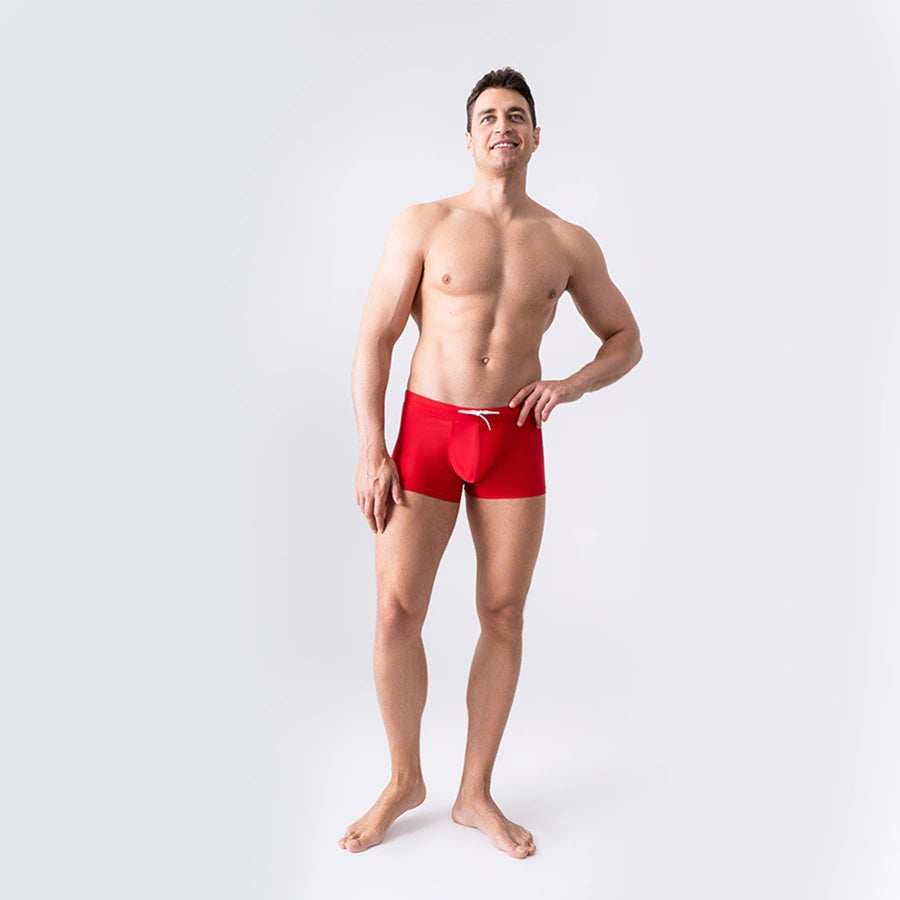 Red anatomical men’s swim trunks by Man’s SET with drawstring waist, breathable pouch, front angled view